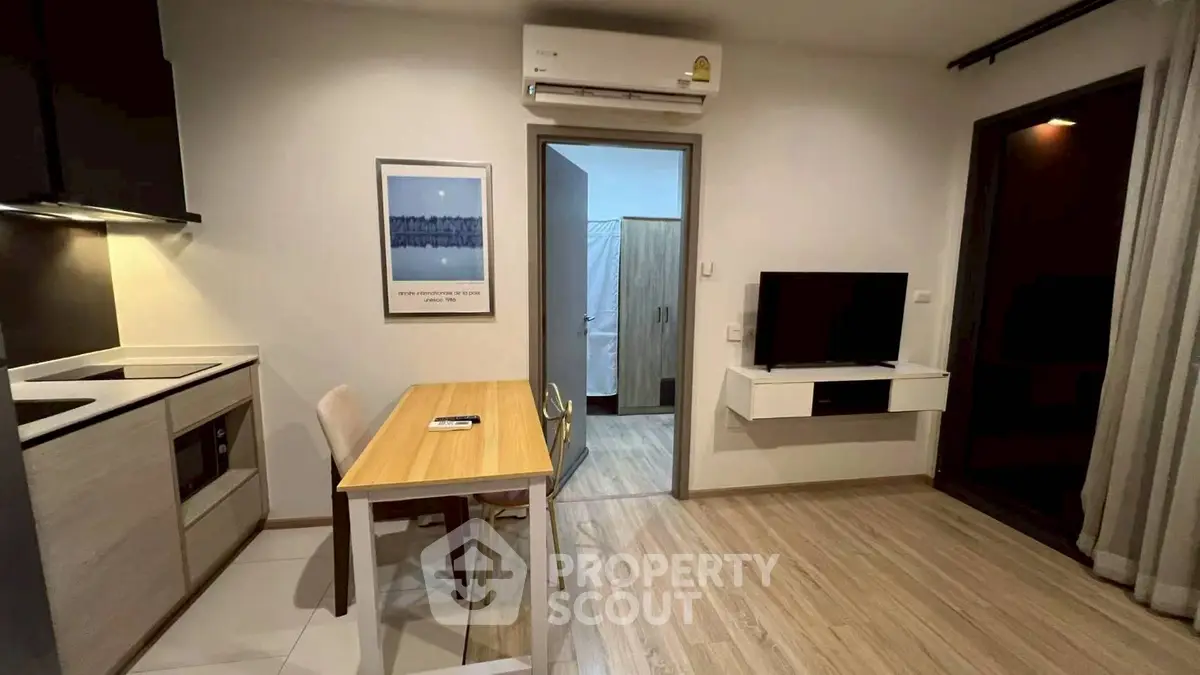 Modern compact living room with kitchen and dining area, featuring sleek design and efficient use of space.