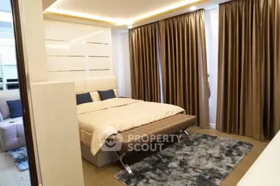 Luxurious bedroom with elegant curtains and plush bedding in modern apartment.