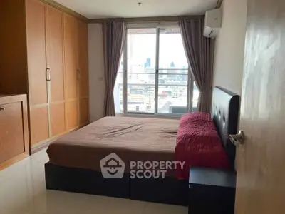 Spacious bedroom with city view and ample storage in modern apartment
