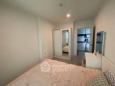 Cozy bedroom with mirrored wardrobe and view into modern kitchen
