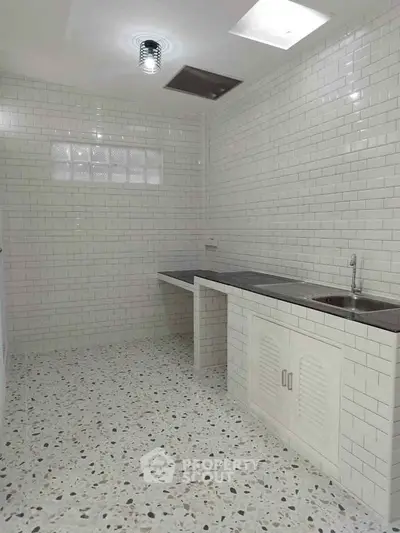 Minimalist kitchen with white brick tiles and terrazzo flooring