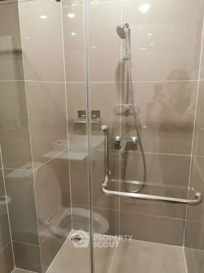 Modern bathroom with sleek shower and glass enclosure in a contemporary apartment.