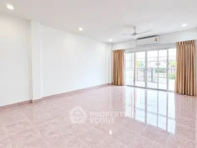 Spacious empty living room with large windows and balcony access, perfect for customization.