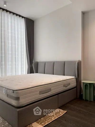 Modern bedroom with stylish grey bed and natural light