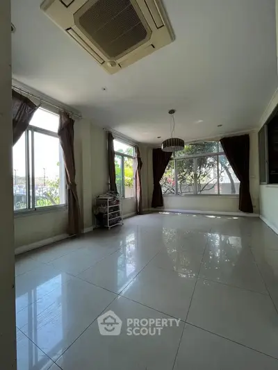 Spacious living room with large windows and natural light, perfect for modern living.