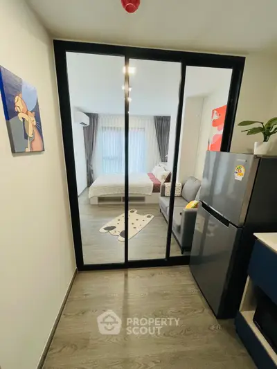 Modern studio apartment with sliding glass doors, cozy living area, and stylish decor.