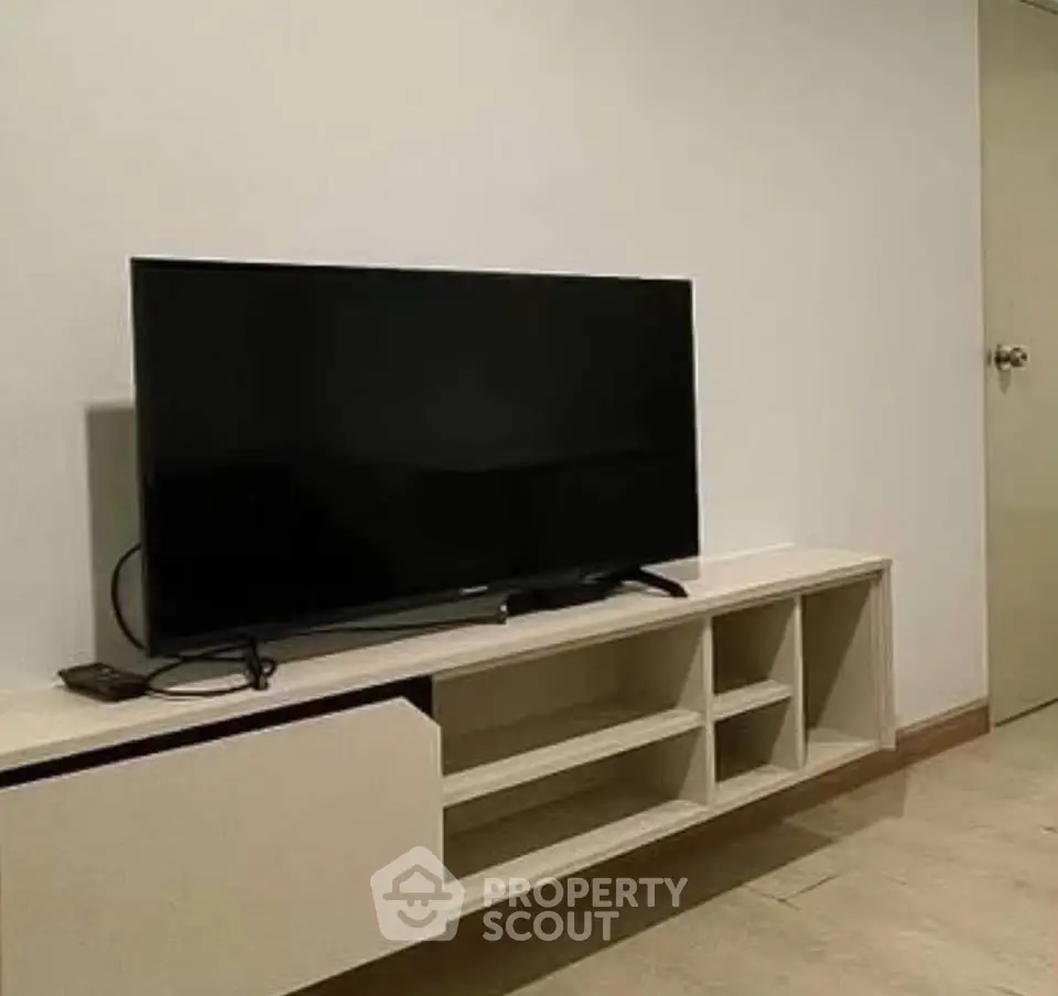 Modern living room with sleek TV stand and flat-screen television, perfect for entertainment.