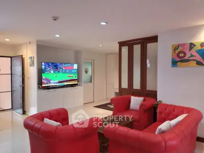 Spacious living room with vibrant red sofas and modern decor, perfect for relaxation and entertainment.