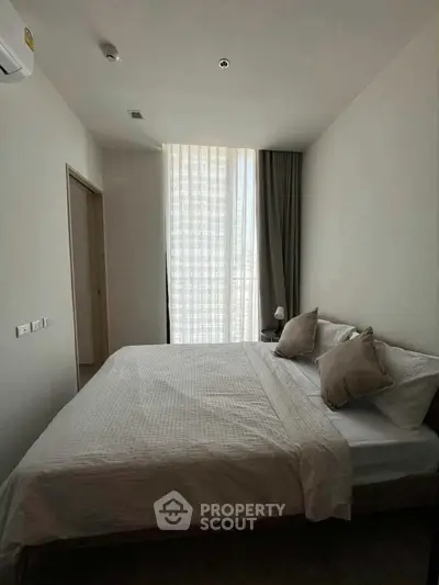 Cozy modern bedroom with natural light and minimalist decor, perfect for relaxation and comfort.