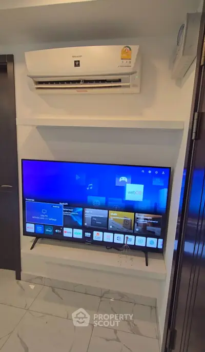 Modern living room with sleek TV setup and air conditioning unit, perfect for entertainment and comfort.