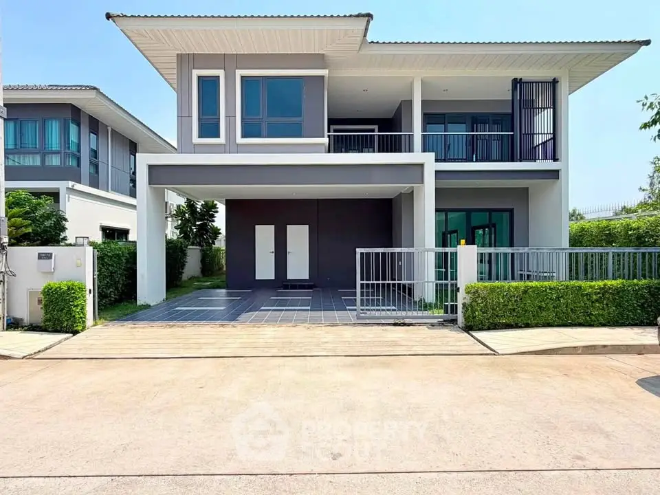 Modern two-story house with sleek design and spacious driveway in a serene neighborhood.