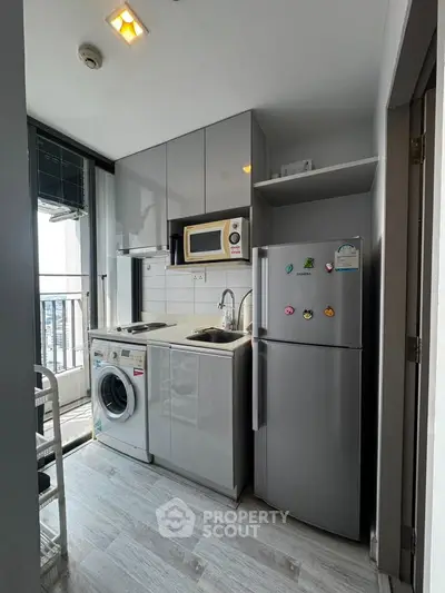 Modern compact kitchen with appliances and balcony view