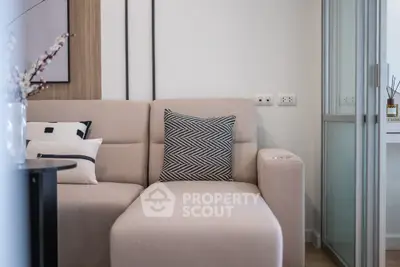 Modern living room with stylish beige sofa and decorative pillows in a cozy apartment.