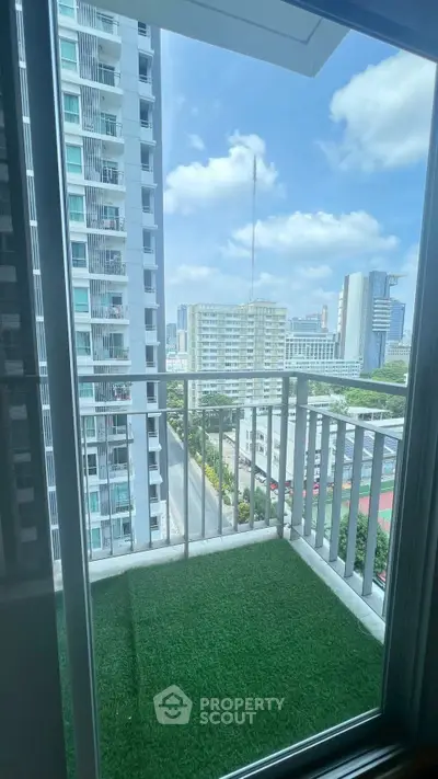 Stunning city view from a modern balcony with artificial grass flooring.