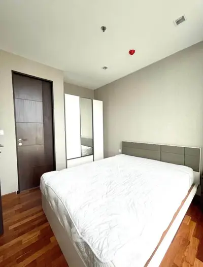 Modern bedroom with wooden flooring and sleek furniture design