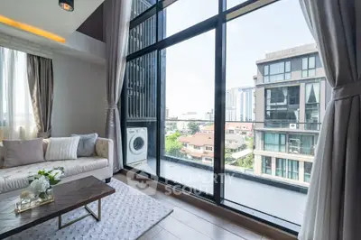Modern living room with large windows offering stunning city views and elegant decor.