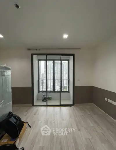 Modern apartment with sliding glass doors leading to a balcony with city views.