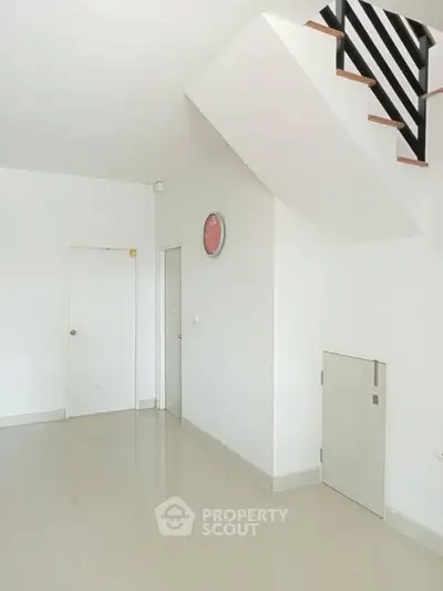 Minimalist interior with staircase and white walls, ideal for modern living spaces.