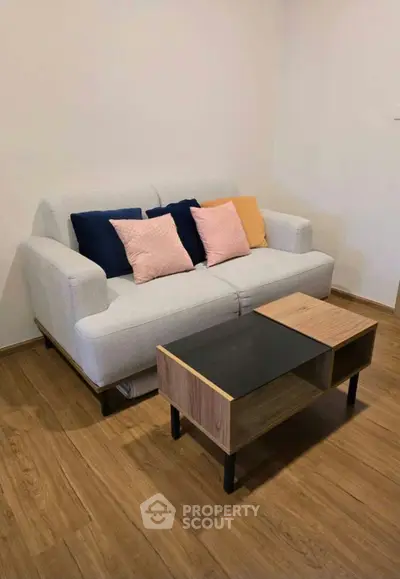 Cozy living room with modern sofa and stylish coffee table on wooden flooring.