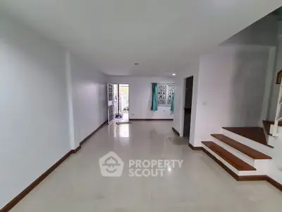 Spacious empty living room with staircase and tiled floor