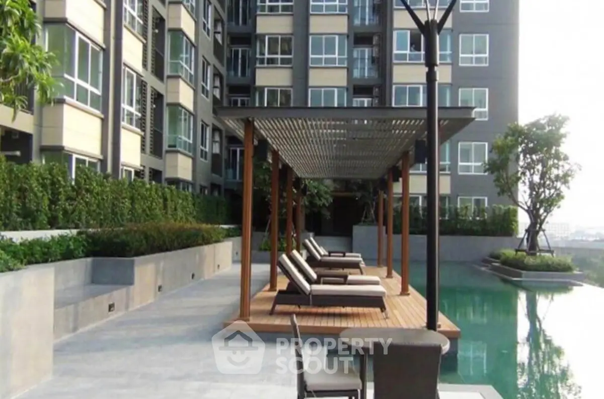 Luxurious apartment complex with poolside lounge area and modern architecture.
