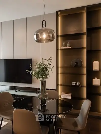 Elegant dining area with modern lighting and stylish shelving in a contemporary home.