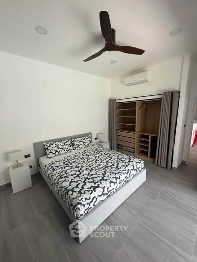 Spacious modern bedroom with stylish decor and ample storage in a contemporary home.