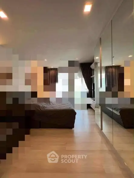 Spacious modern living room with large windows and mirrored wall