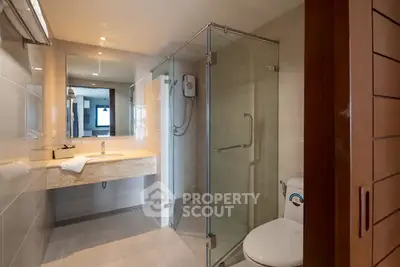 Modern bathroom with glass shower and sleek fixtures in a contemporary home.