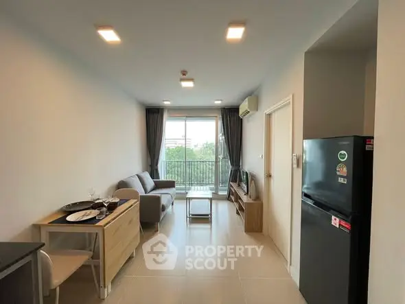 Modern living room with balcony view, featuring sleek furniture and natural light.
