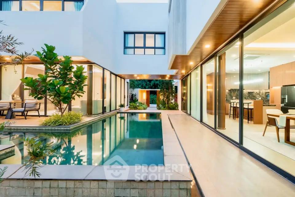 Luxurious modern home with stunning pool and open kitchen view, perfect for elegant living.