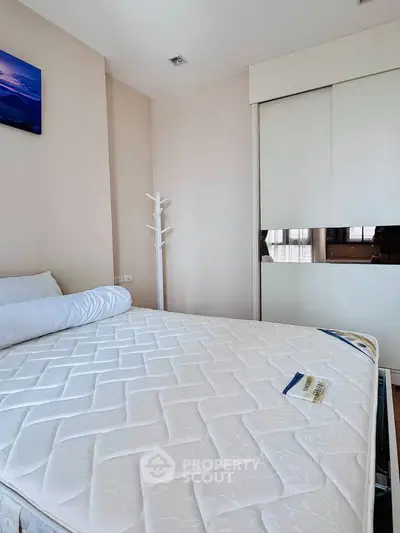 Cozy bedroom with modern decor and ample natural light, featuring a comfortable bed and sleek wardrobe.