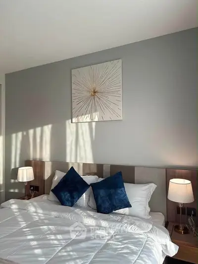 Modern bedroom with stylish decor and cozy lighting, featuring a comfortable bed and elegant wall art.