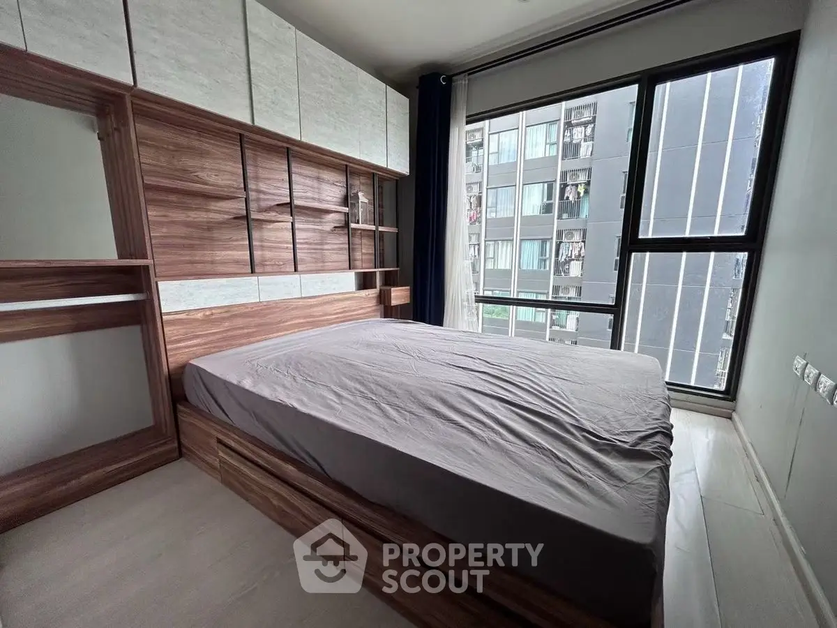 Modern bedroom with large window and stylish wooden furniture