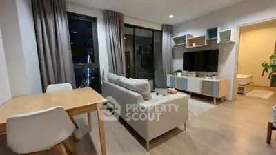 Modern living room with stylish decor and open layout, featuring a cozy sofa and entertainment center.