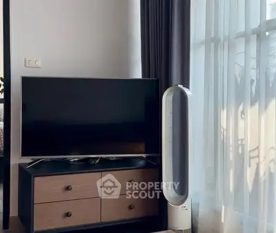 Modern living room with sleek TV and stylish fan by large window