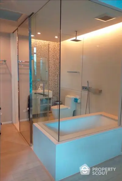 Luxurious modern bathroom with glass shower and bathtub in elegant apartment.