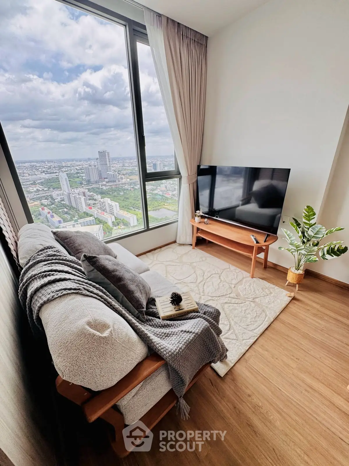 Cozy living room with panoramic city view, modern decor, and natural light.