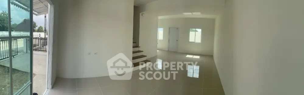 Spacious modern living room with glossy tiled floors and large windows for natural light.