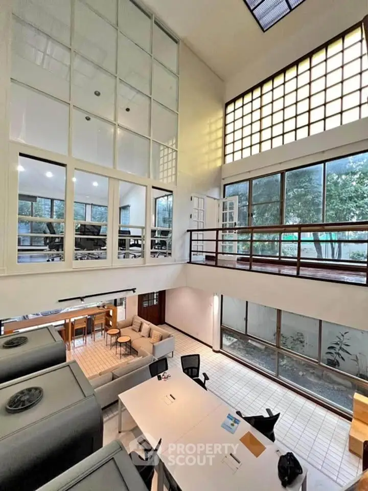 Spacious modern living area with high ceilings and large windows offering natural light.