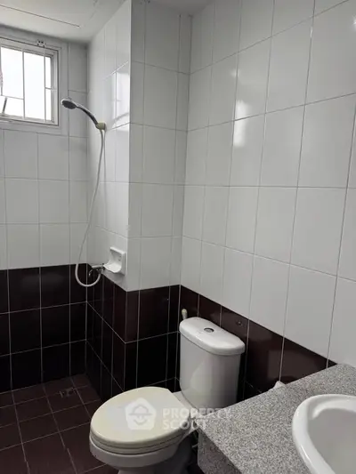 Modern bathroom with tiled walls and shower in real estate property