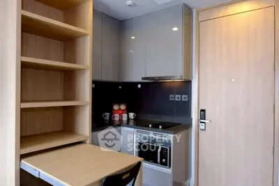 Compact modern kitchen with sleek cabinets and built-in appliances in a cozy apartment.