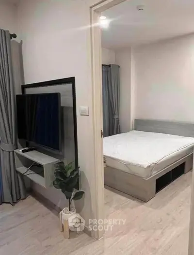 Modern apartment interior with cozy bedroom and sleek TV setup.