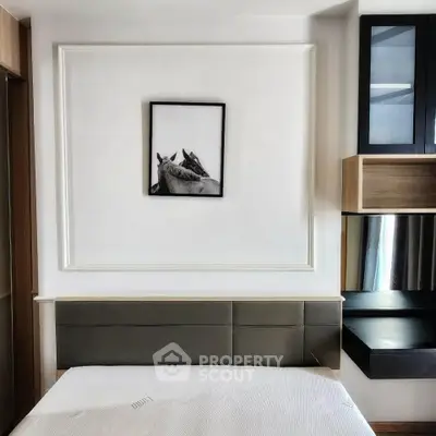 Modern bedroom with sleek design and stylish wall art, featuring built-in storage and elegant decor.