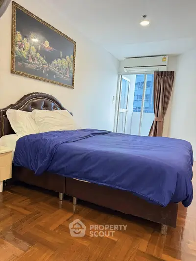 Cozy bedroom with elegant decor and natural light from large window, perfect for relaxation.