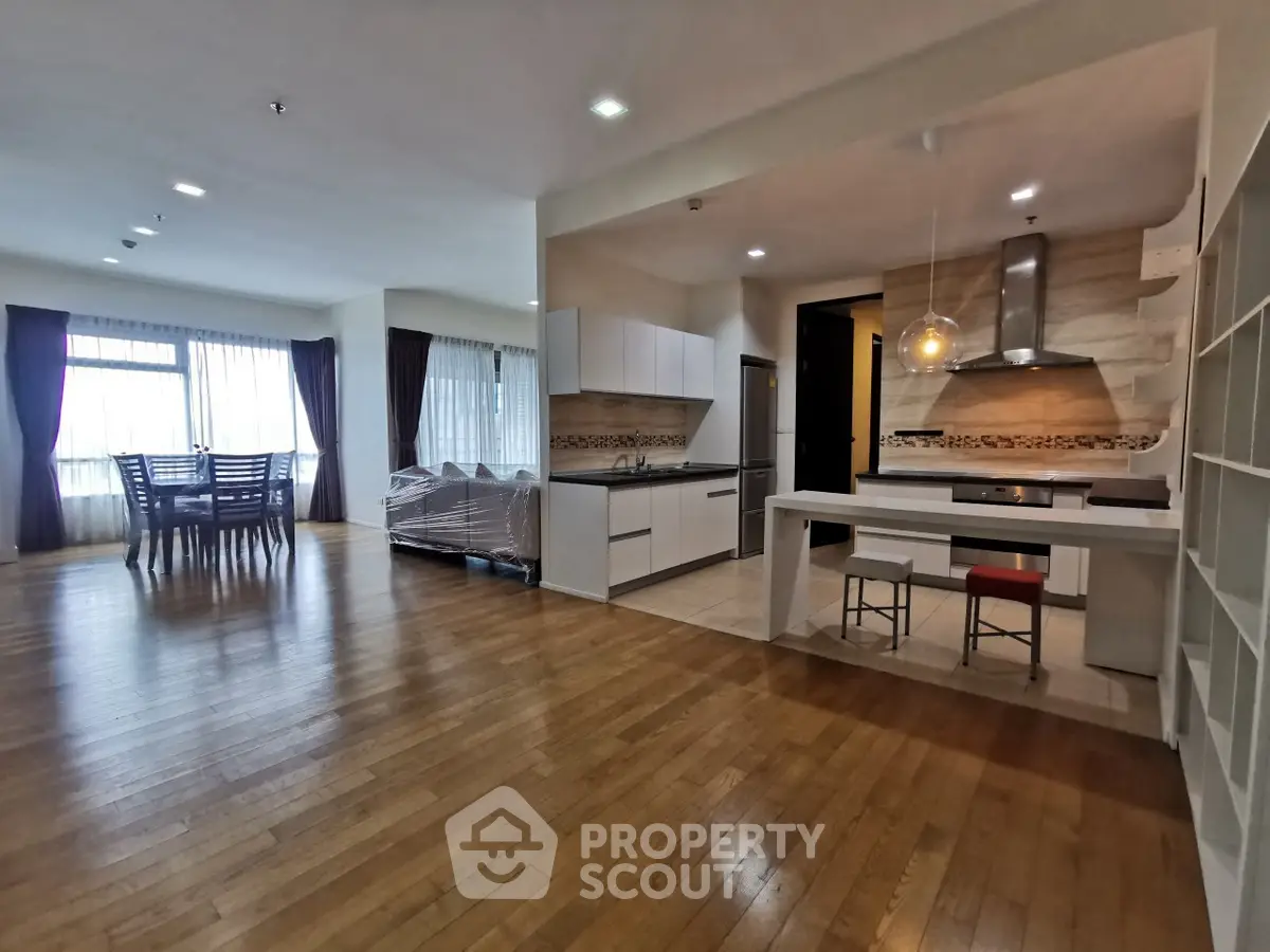 Spacious open-plan living and dining area with modern kitchen and large windows.