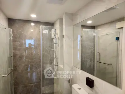 Modern bathroom with glass shower enclosure and sleek fixtures