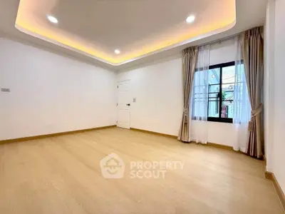 Spacious empty room with elegant ceiling lights and large window, perfect for customization.