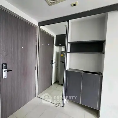 Modern entryway with sleek storage and mirrored door in contemporary apartment