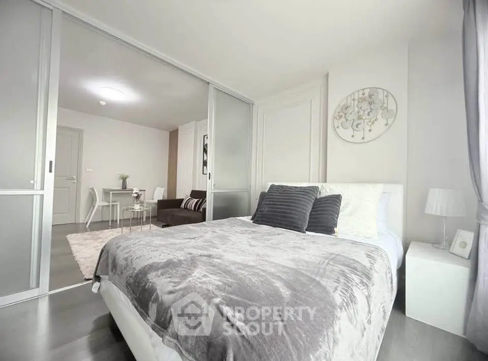 Modern bedroom with sliding glass doors and cozy decor in a stylish apartment.